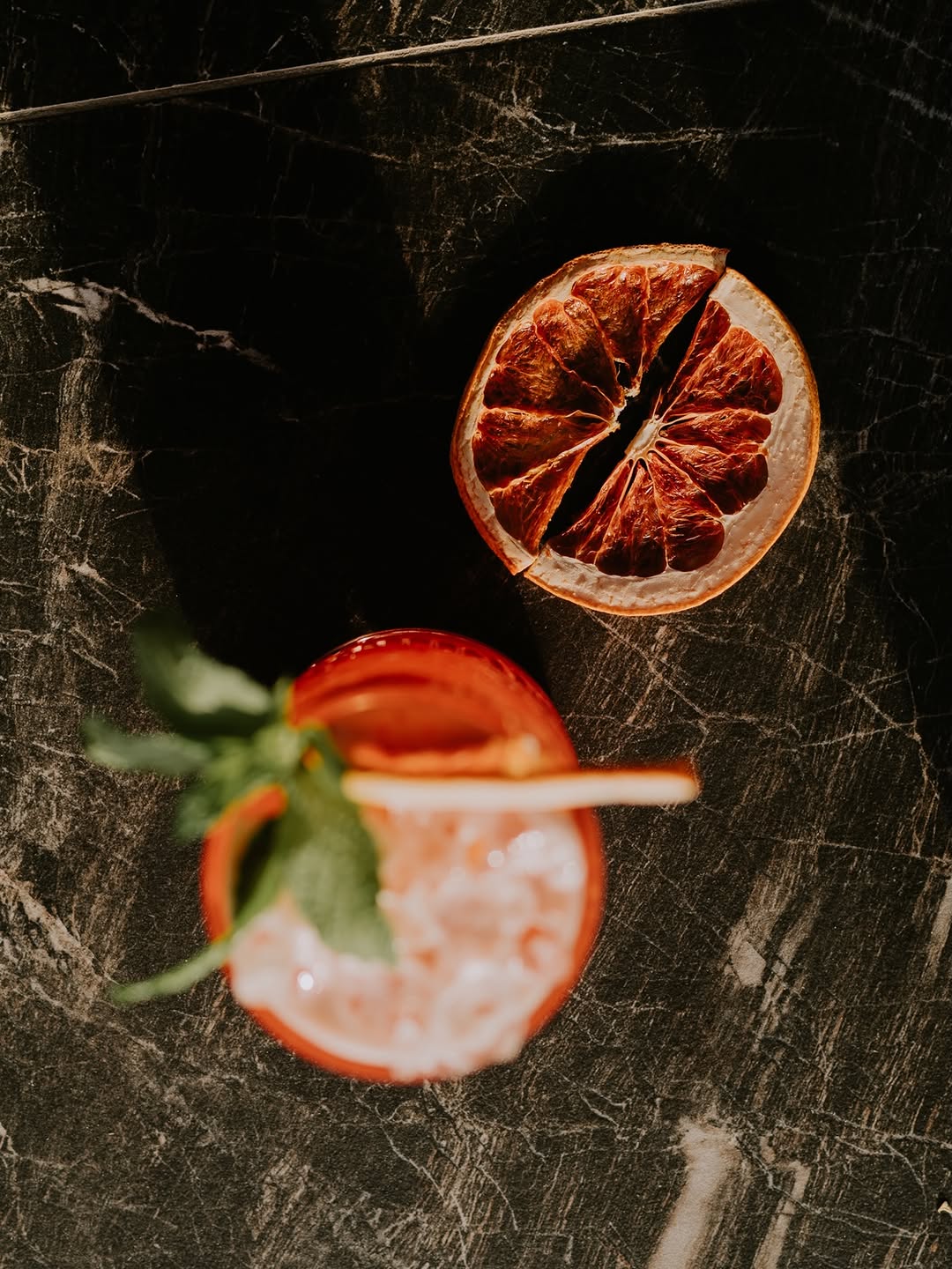 Cocktail και αποξηραμένο γκρέιπφρουτ σε μαύρο μάρμαρο