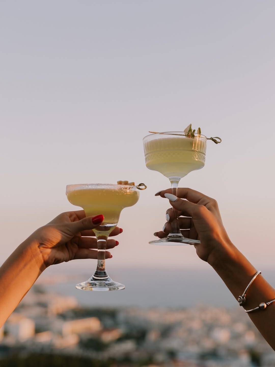 Δύο margarita σηκώνονται ψηλά πάνω από την πόλη