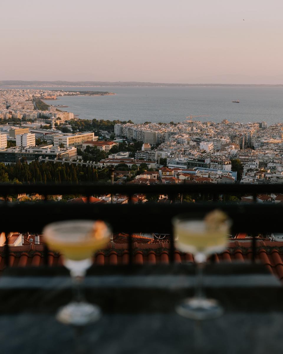 Δύο cocktails στο τραπέζι με θέα την πόλη και τη θάλασσα